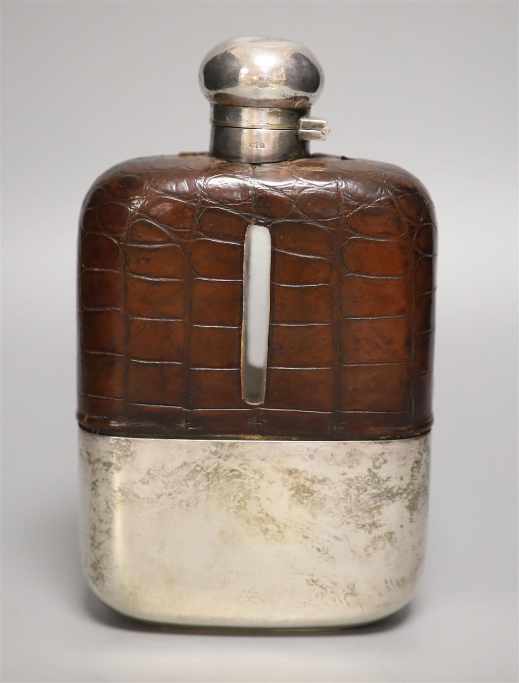 A clear cut glass and silver-plated oversized hip flask by James Dixon & Sons, crocodile jacketed,